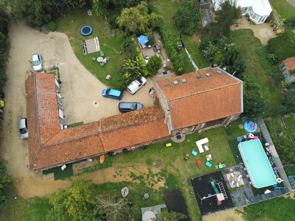 einen Blick über ein altes Backsteingebäude mit geparkten Autos in der Unterkunft Willow Barn in Wisbech