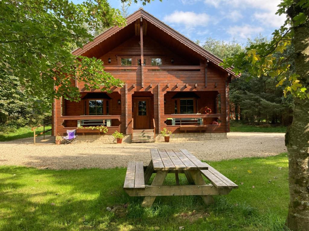 a wooden cabin with a picnic table in front of it at Riverside log cabin in Ballyconnell