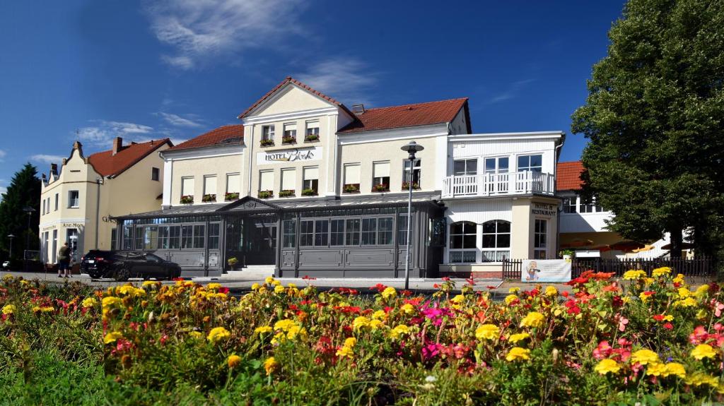 ein großes weißes Gebäude mit Blumen davor in der Unterkunft Hotel Bleske im Spreewald in Burg