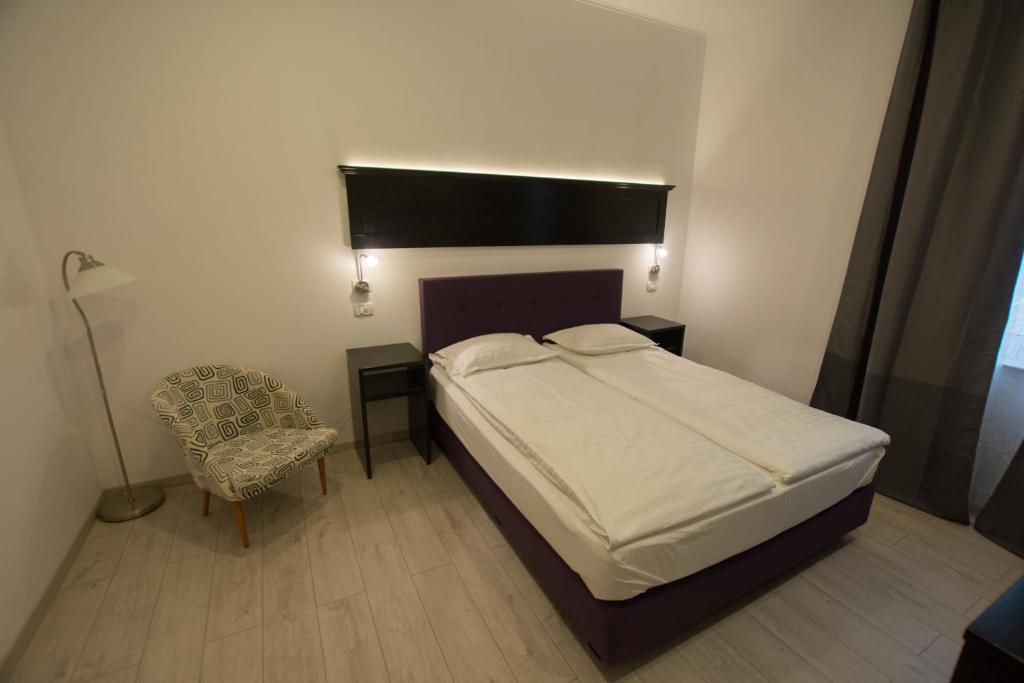 ein Schlafzimmer mit einem Bett, einem Stuhl und einer Lampe in der Unterkunft Casa Branga in Deva