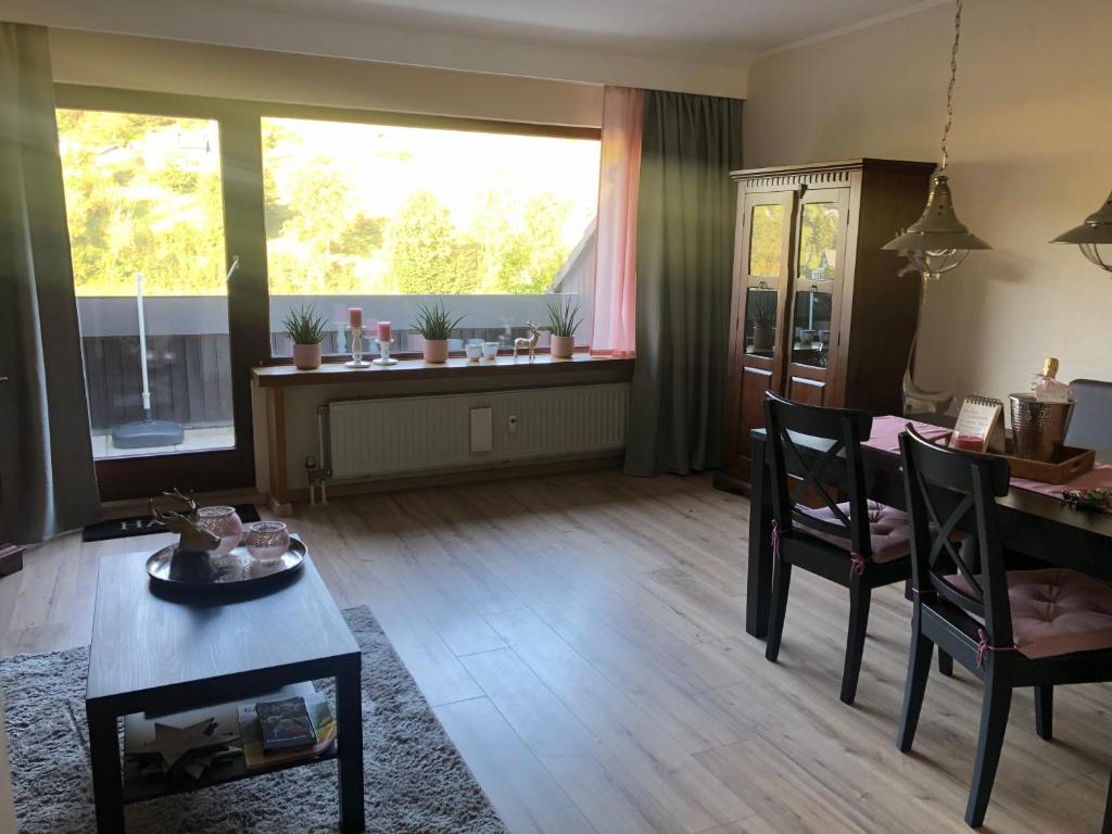 een woonkamer met een tafel en stoelen en een raam bij Kleine Auszeit Winterberg in Winterberg