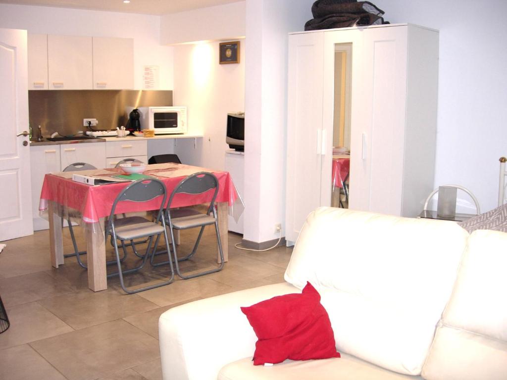 een woonkamer met een bank en een tafel en een keuken bij La Quietude in Chaudfontaine