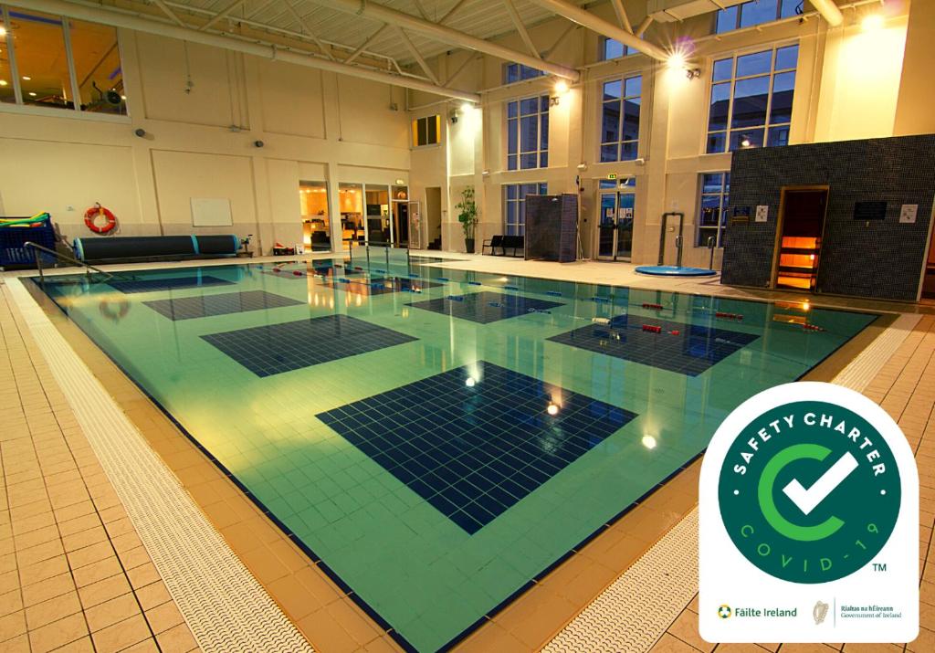 
a large swimming pool in a large building at Clybaun Hotel in Galway
