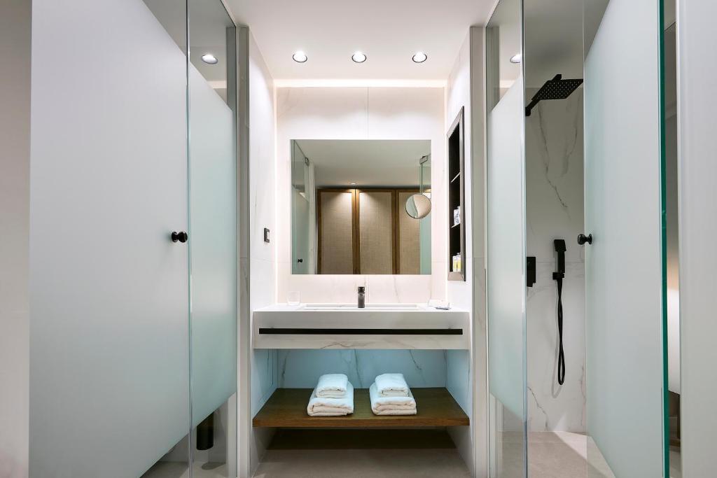 a bathroom with a sink and a mirror at Michelangelo Resort & Spa in Ágios Fokás