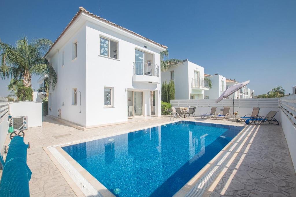a villa with a swimming pool in front of a house at Palm Villa 17 in Protaras