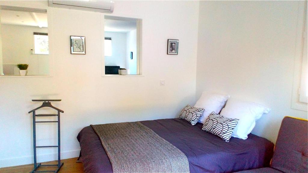 una camera con letto, specchio e divano di STUDIO Jasmin & Jardin 1 à 2 pers à Villa Terra a Balma