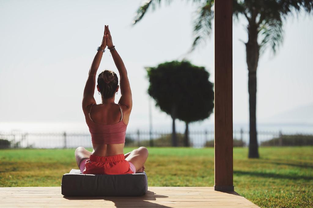a woman doing a yoga pose in a park at Michelangelo Resort & Spa in Ágios Fokás