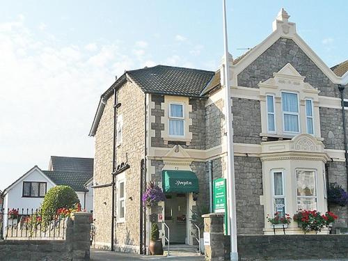 a large brick house with a sign in front of it at Spreyton Guest House in Weston-super-Mare