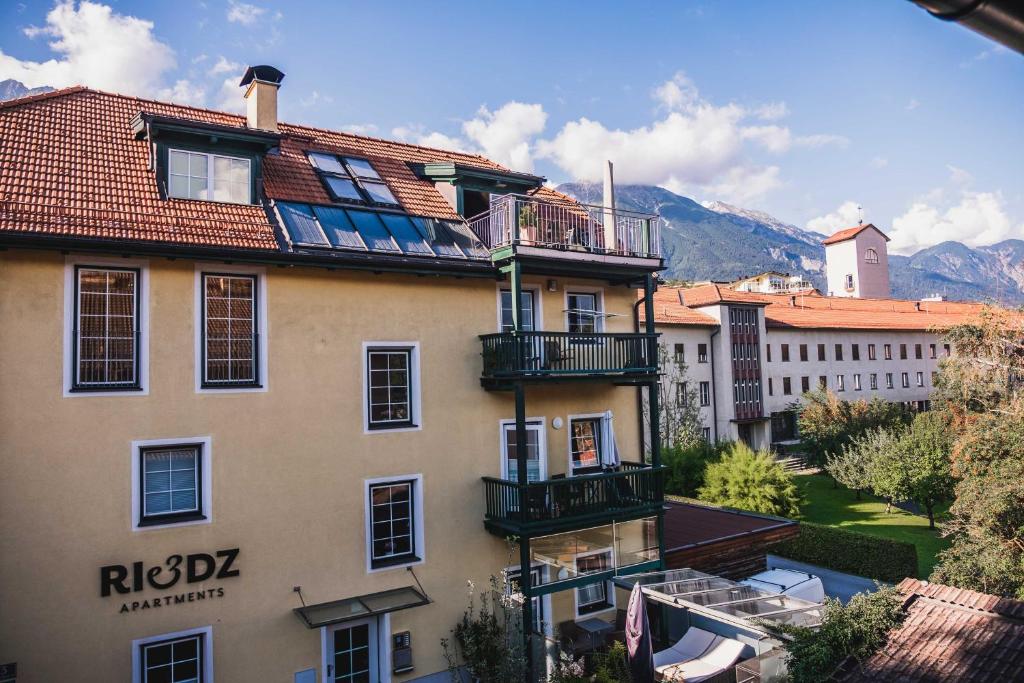 um edifício com uma varanda ao lado em Riedz Apartments Innsbruck- Zentrales Apartmenthaus mit grüner Oase em Innsbruck