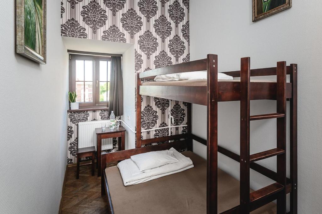 a room with a bunk bed with a ladder at MoHo E Hostel in Wrocław