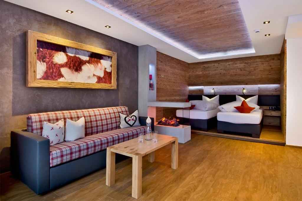 uma sala de estar com um sofá e uma cama em PETE - Alpine Boutique Hotel em Sankt Anton am Arlberg