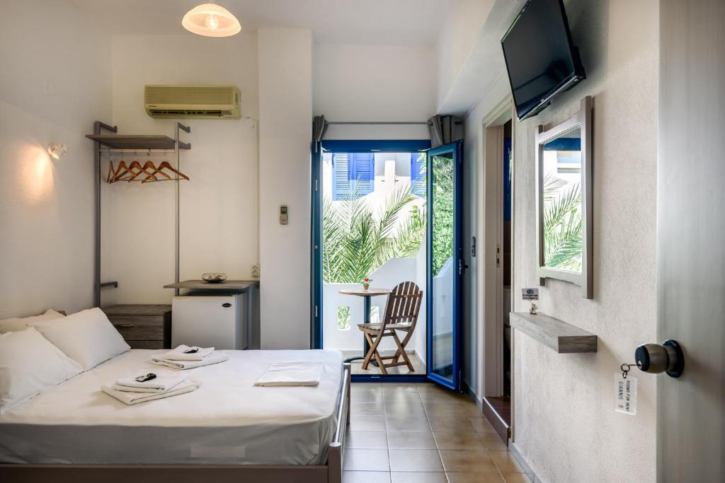 a hotel room with a bed and a balcony at Giannis studio Agia Roumeli in Agia Roumeli