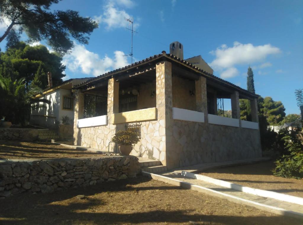 a house with a stone wall at Villa Carmen - Chalet privado con piscina, jardín y barbacoa in Alcossebre