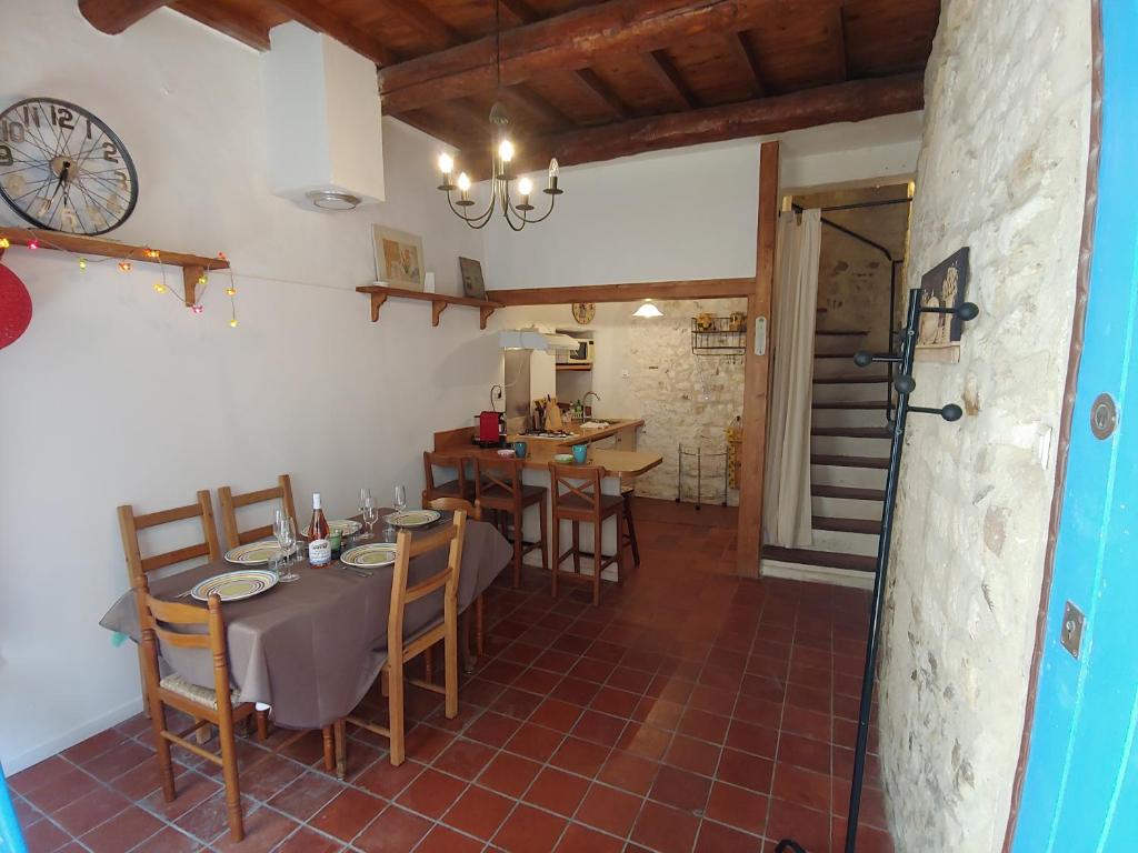 une salle à manger avec une table et des chaises et une cuisine dans l'établissement Charmante maison arlésienne à l'ombre des Arènes, de 2 à 5p, à Arles