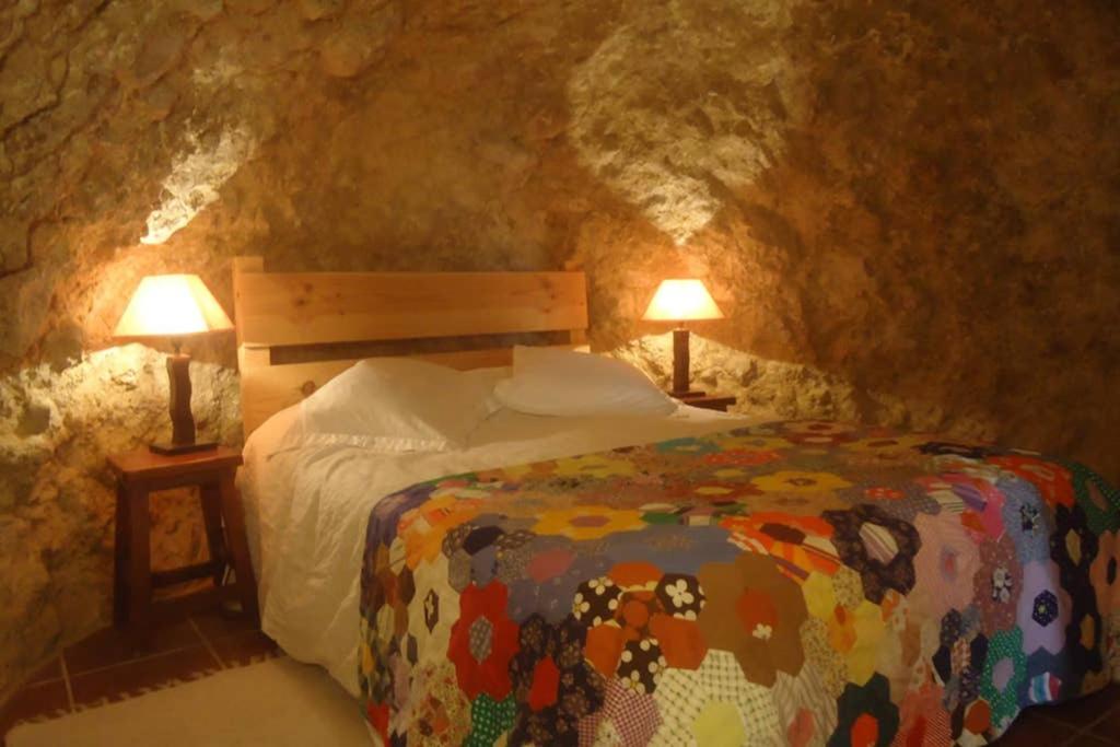 1 dormitorio con 1 cama y 2 lámparas en una cueva en Cueva Santa Cruz, en Alicante