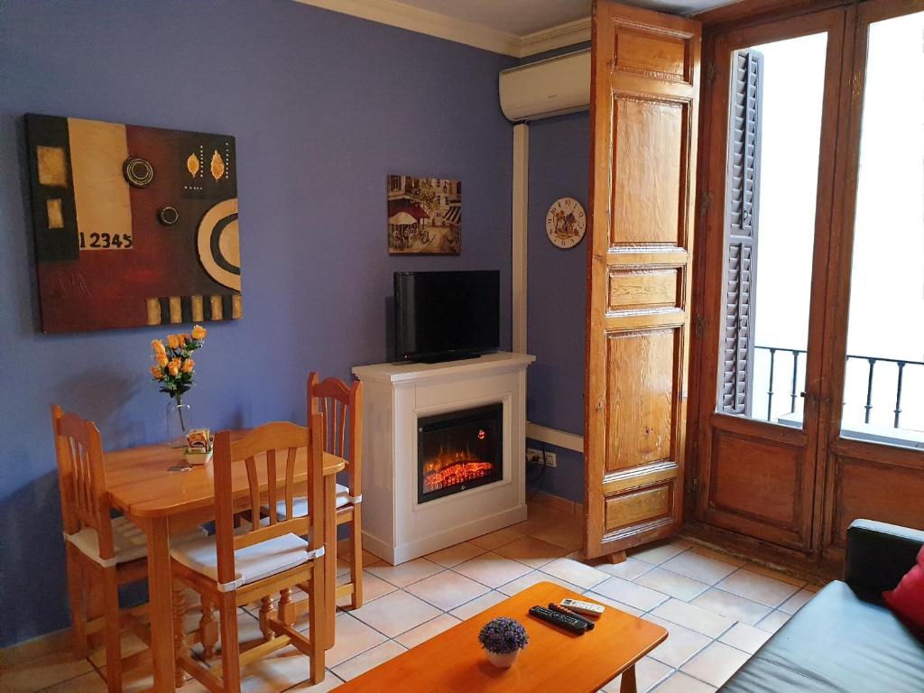 ein Wohnzimmer mit einem Tisch und einem Kamin in der Unterkunft Apartamentos Dana Sol in Madrid
