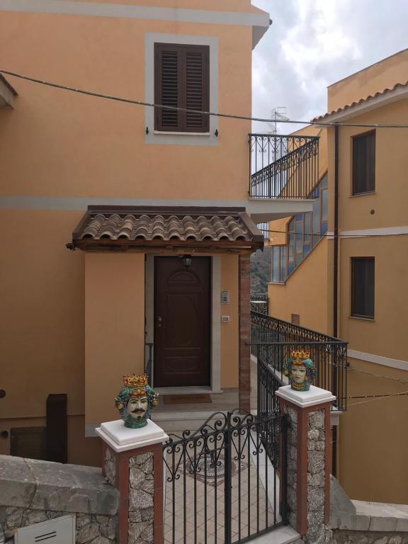 a house with a gate with two vases on it at Casa Vacanza Cundari in Castelmola