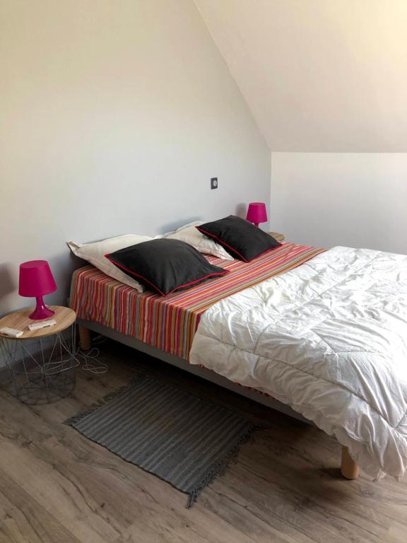 una camera con un grande letto e un tavolo rosso di O Bord de la mer a Saint-Pierre-Quiberon
