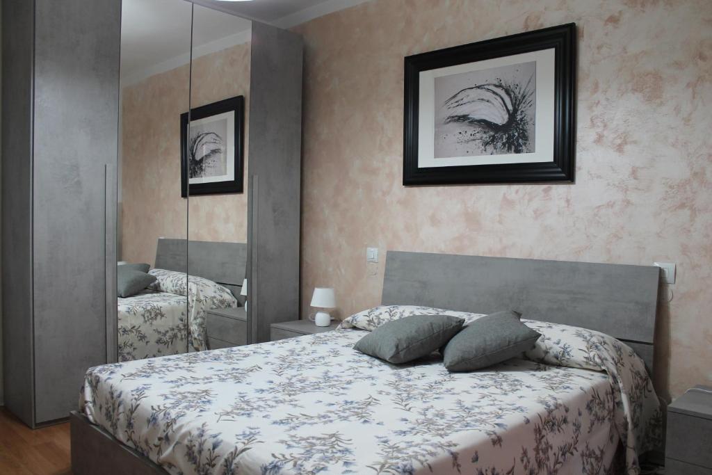 a bedroom with a bed and a large mirror at Appartamento Tilli in Perugia