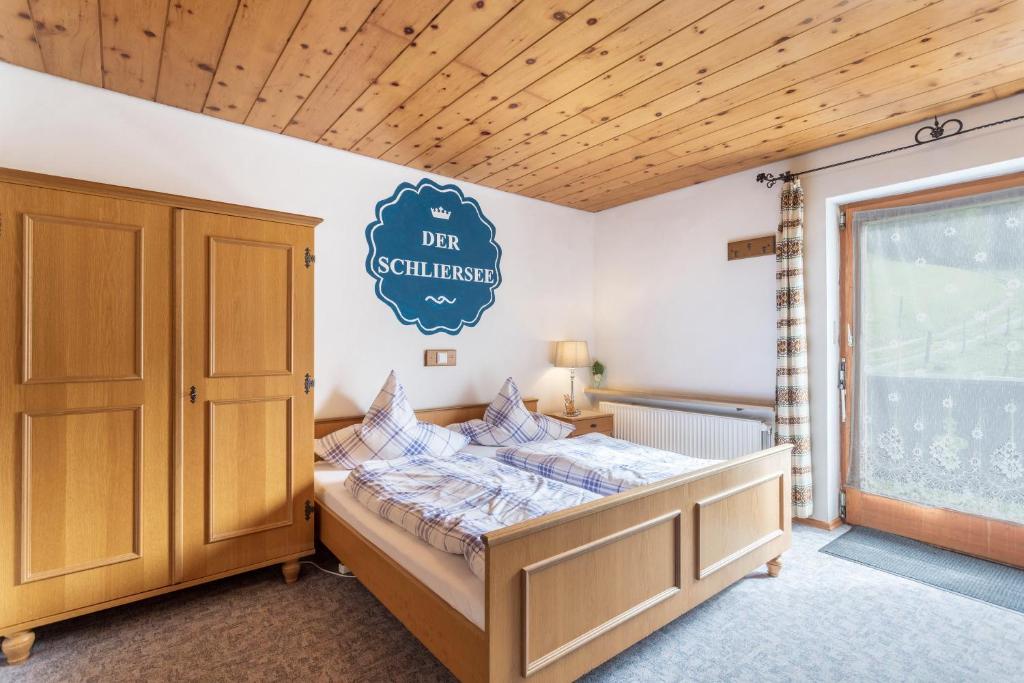 a bedroom with a bed and a sign on the wall at Ferienwohnung Rohnberg in Schliersee