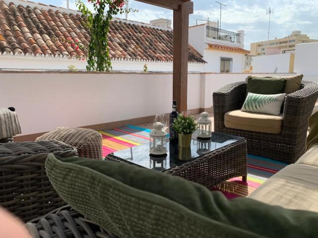 a patio with wicker chairs and a table on a roof at Casita Bonita Old Town Marbella in Marbella