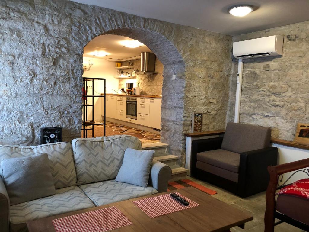 a living room with a couch and a stone wall at Kauba 6a apartment in Kuressaare