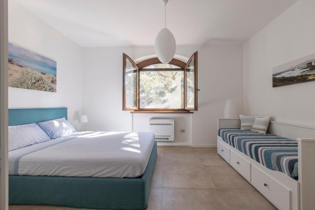 une chambre avec deux lits et une fenêtre dans l'établissement Villa Tellus, à Stintino