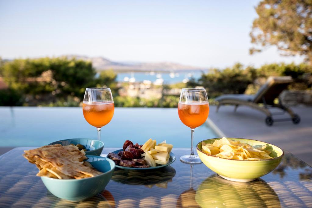 - une table avec deux verres de vin et une assiette de nourriture dans l'établissement Villa Tellus, à Stintino