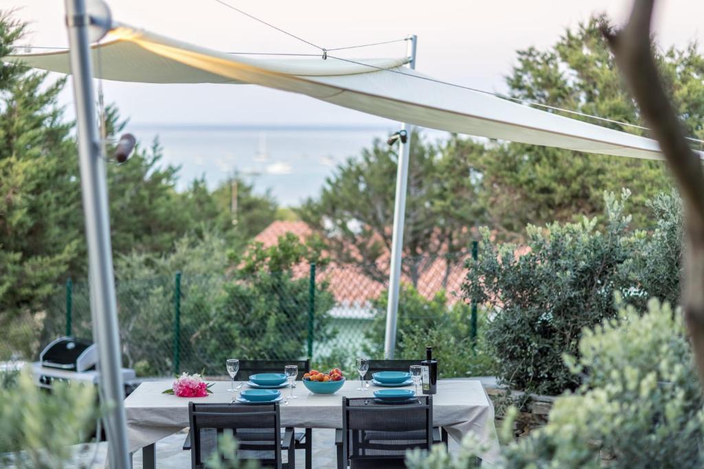 une table et des chaises sous un parasol blanc dans l'établissement Villa Tellus, à Stintino