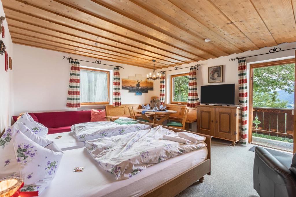 - une chambre avec un lit, un canapé et une télévision dans l'établissement Ferienwohnung Oberrißglück, à Schliersee