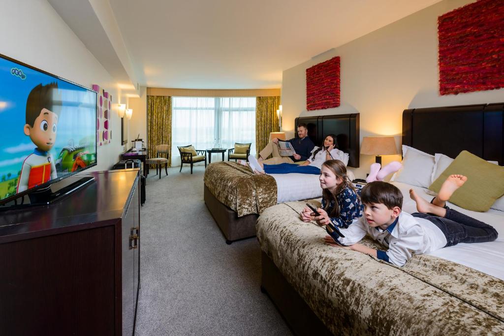 two children sitting on beds in a hotel room at Cork International Hotel in Cork