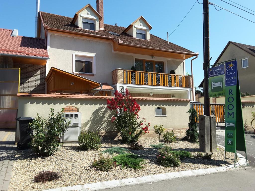 a white house with a balcony on a street at Eurovelo6 Stop in Solt