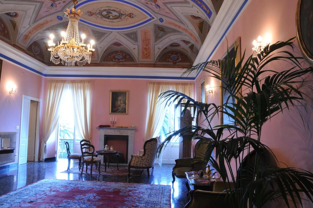 a living room with a chandelier and a table and a plant at Casa Pagliano in Noli