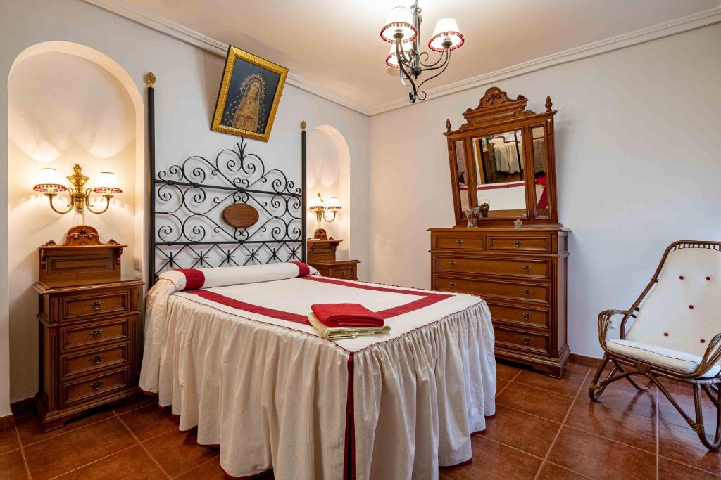 Schlafzimmer mit einem Bett, einer Kommode und einem Spiegel in der Unterkunft Casa rural Crisalva in Granátula de Calatrava
