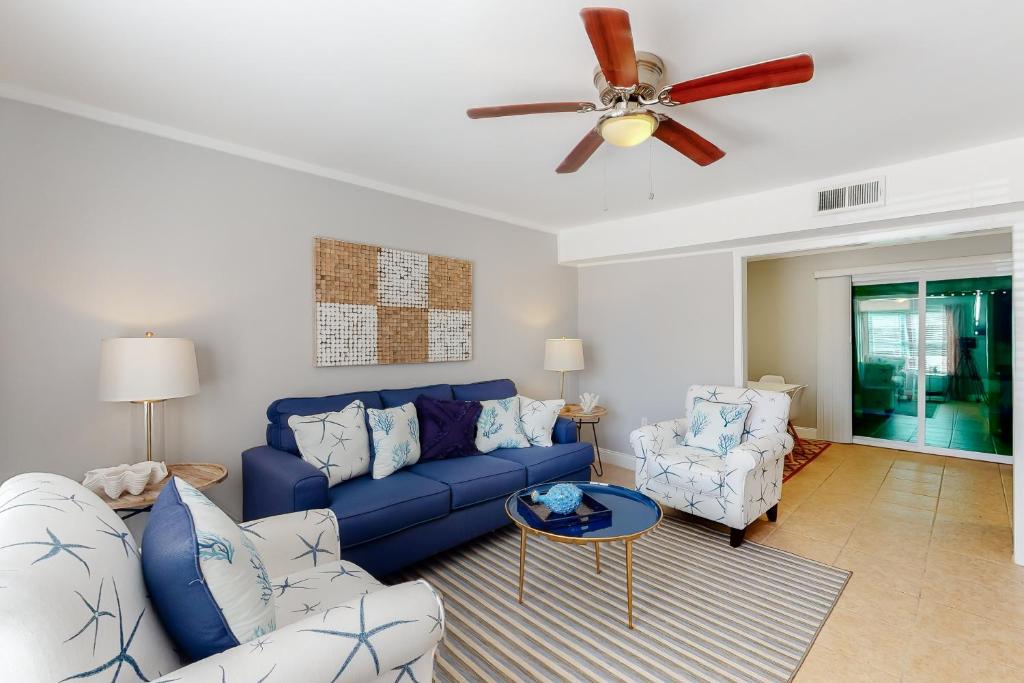 a living room with a blue couch and two chairs at Southern Sunsets in Destin