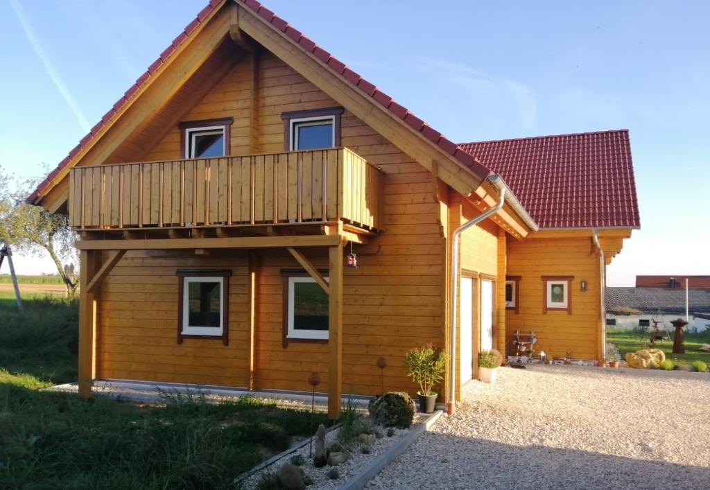 ein Holzhaus mit Balkon oben in der Unterkunft Ferienwohnung Geyer in Rennertshofen