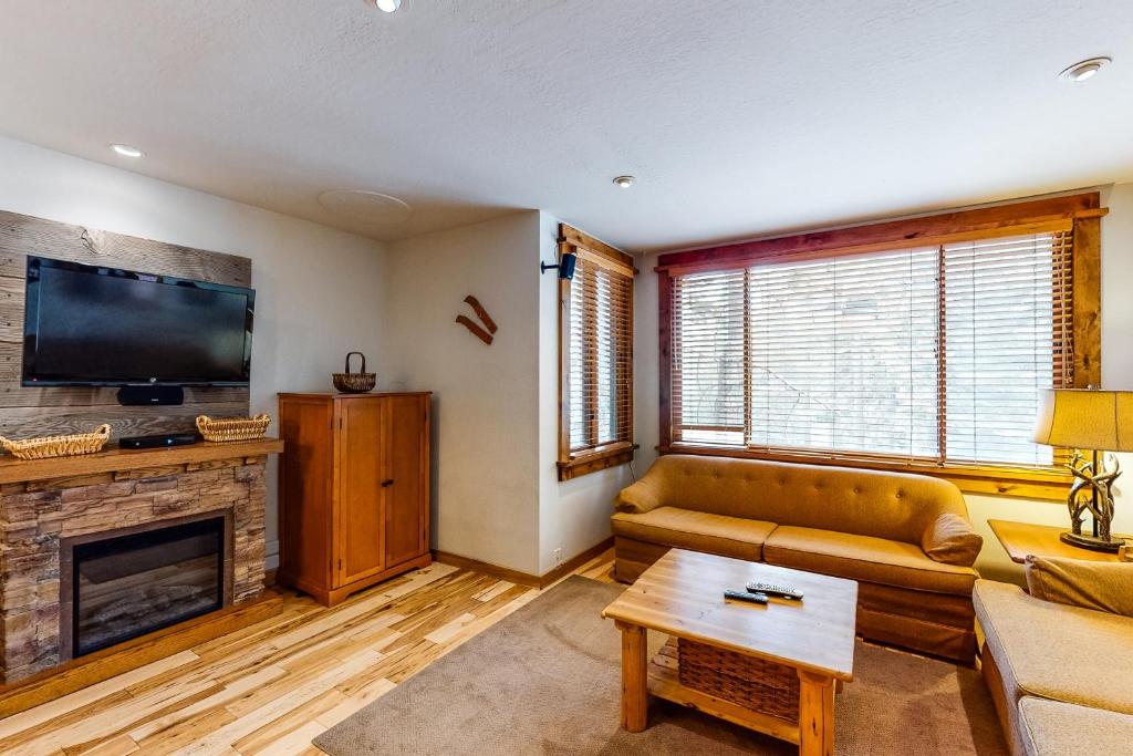 a living room with a couch and a fireplace at Cozy Condo in Ski Trails in Truckee