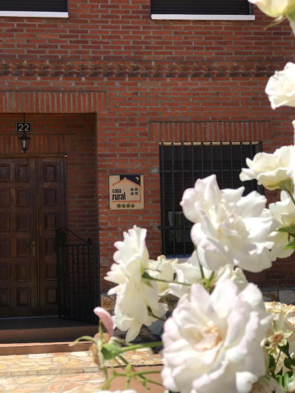 a bunch of white flowers in front of a brick building at Casa Rural Alaejos in Alaejos