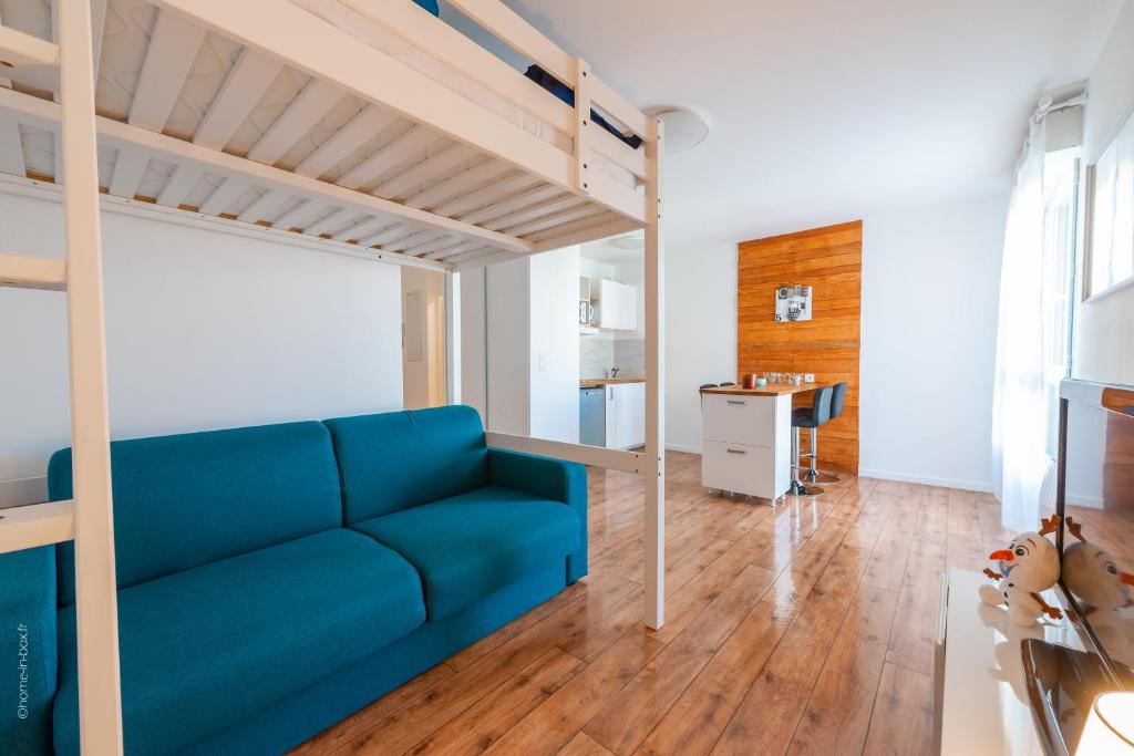 - un salon avec un canapé bleu et une mezzanine dans l'établissement Beautiful apartment 8min Disney, à Montévrain