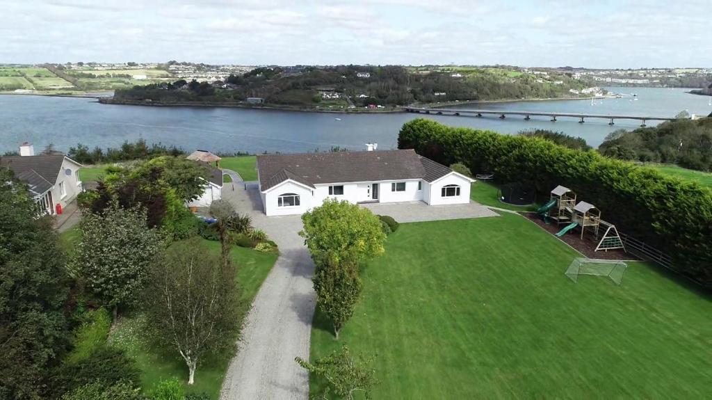 an aerial view of a white house on a lawn next to a lake at Marina views, Kinsale, Exquisite holiday homes, sleeps 20 in Kinsale