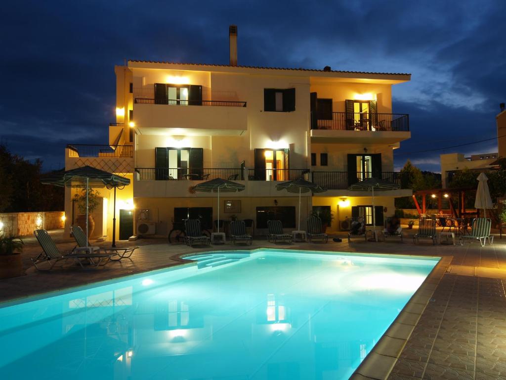 a villa with a swimming pool in front of a house at Irida Apartments -EX BLAZIS HOUSE in Almyrida