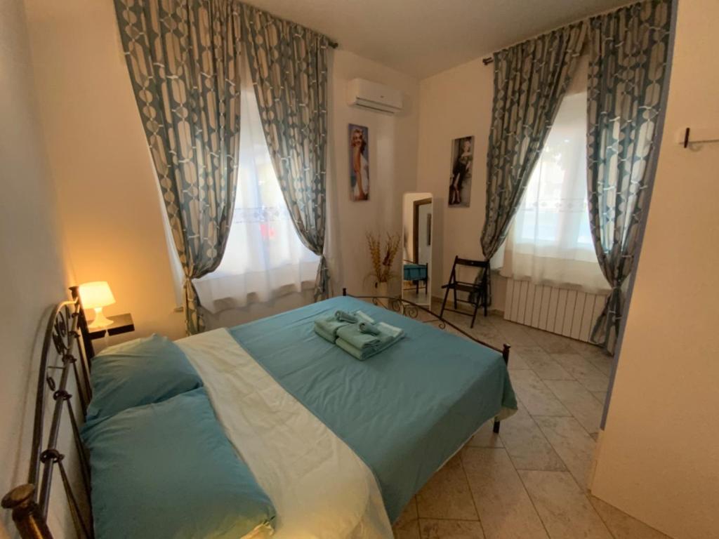 een slaapkamer met een bed en 2 ramen bij Parma Holiday 2020+21 in Parma