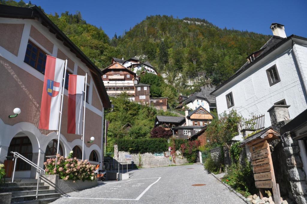 a street in a village with flags on buildings at Apartment Müllerstiege in Hallstatt