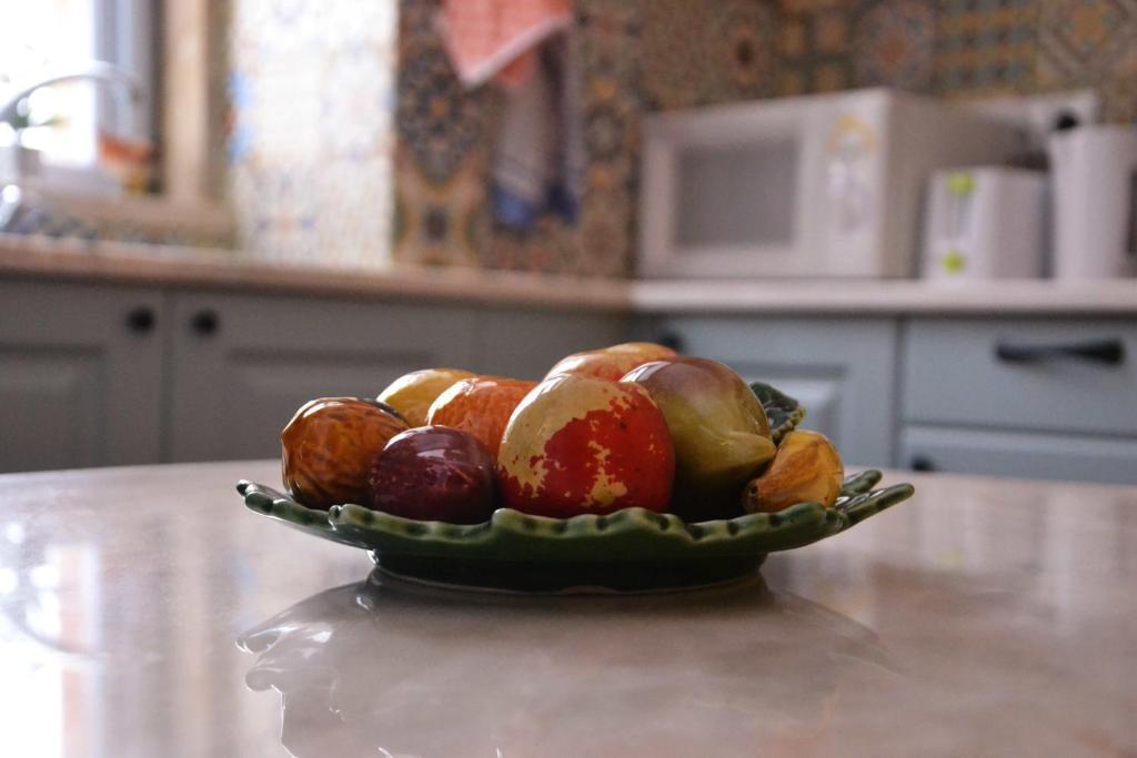 a bowl of fruit on a table in a kitchen at Casa da Nonô in Coimbra