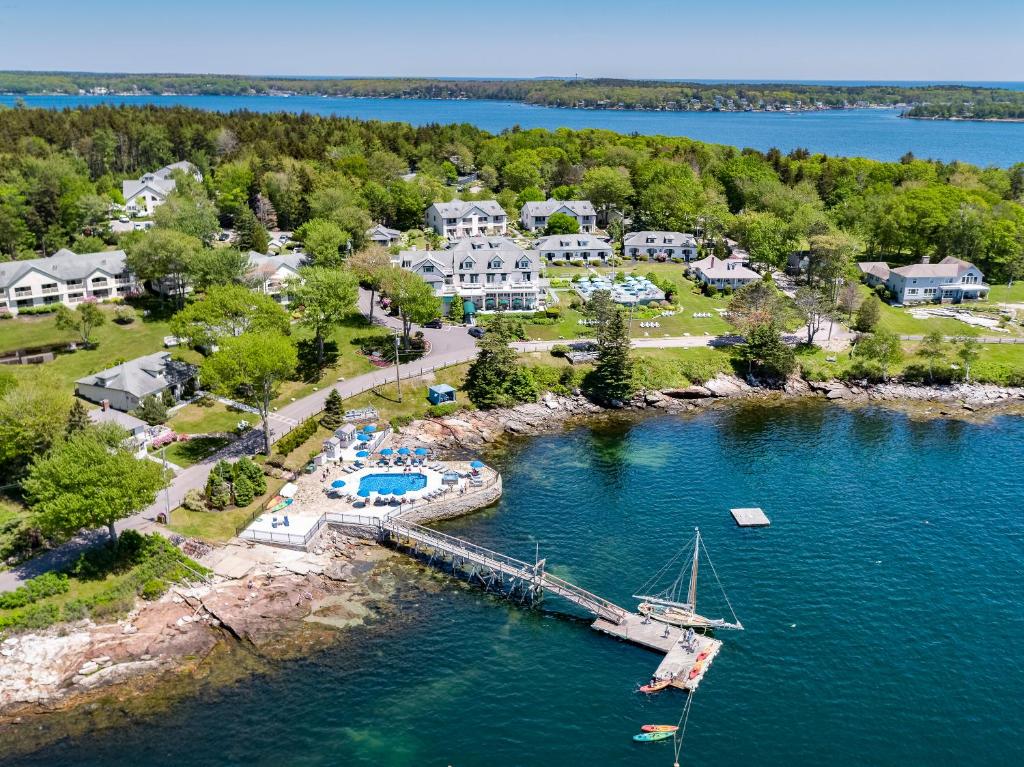 an aerial view of a home with a boat in the water at Spruce Point Inn Resort and Spa in Boothbay Harbor