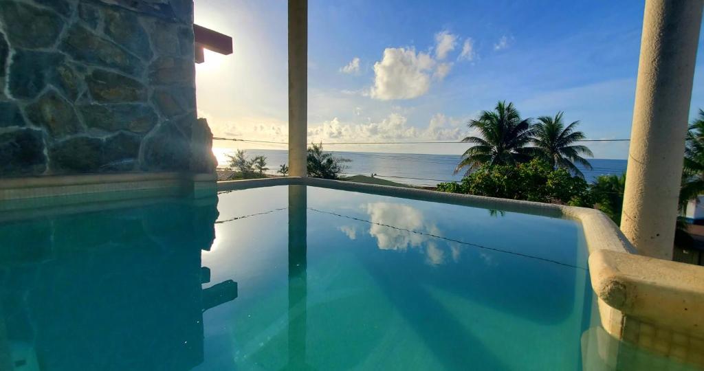 a swimming pool with a view of the ocean at Layla Guesthouse in Puerto Morelos