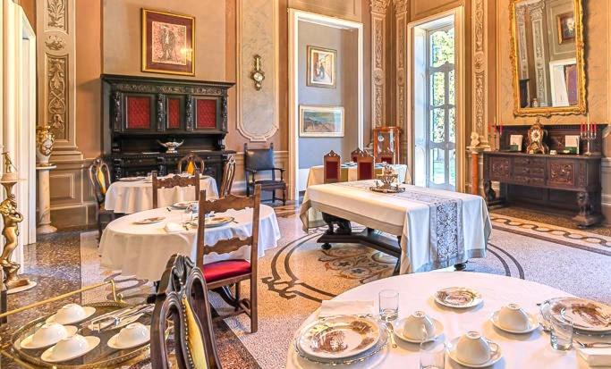 a room with two tables and a piano in it at Charme of Villa Capannina in Novi Ligure