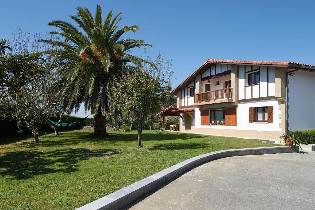 une maison avec un palmier à côté d'un bâtiment dans l'établissement Casa Rural La Palmera - Landetxea, à Lasarte