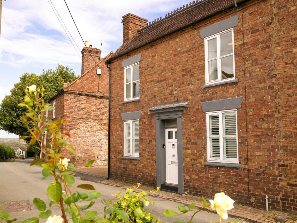 a brick house with a white door at IRONBRIDGE - 18th CENTURY THREE BEDROOM COTTAGE - 6 BEDS in Ironbridge