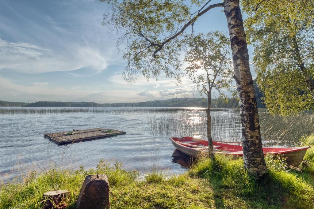 un par de barcos en un lago con muelle en Lake cottage near Isaberg, en Åsenhöga